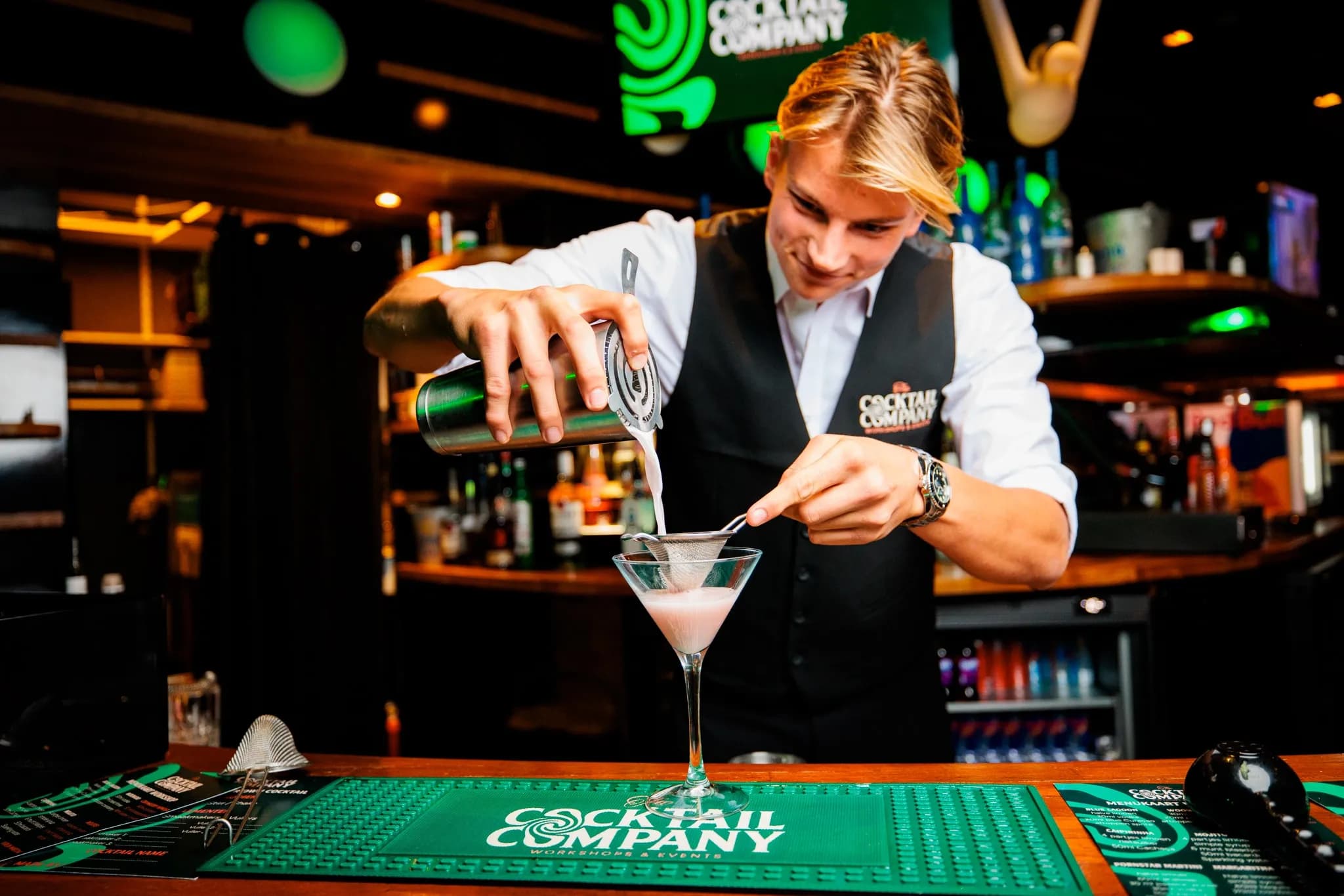 Cocktailshaker die een cocktail bereid op een bedrijfsfeest